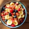 Bowl of fruit and oatmeal with nuts.