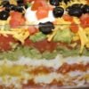 Colorful seven-layer dip in a clear dish.