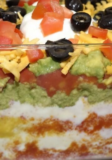 Colorful seven-layer dip in a clear dish.