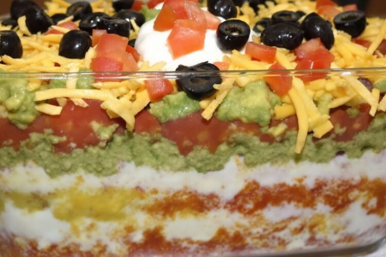 Colorful seven-layer dip in a clear dish.