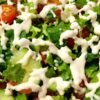 Fresh salad with vibrant vegetables and creamy dressing.