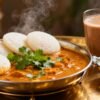 Indian breakfast spread with idli, sambar, and chai.
