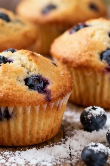 Healthy blueberry breakfast muffins on a wooden table.