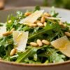 Rocket salad with dressing and toppings.