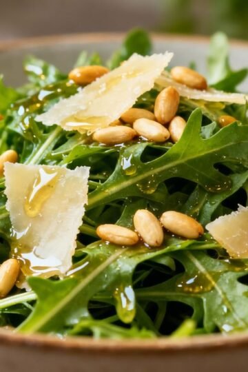 Rocket salad with dressing and toppings.