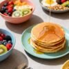 Healthy egg-free breakfast spread with fruits and pancakes.