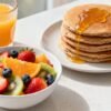 Healthy pregnancy breakfast ideas: fruit, pancakes, and juice.