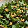 Rocket salad with balsamic glaze and pine nuts.