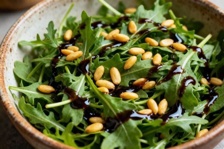 Rocket salad with balsamic glaze and pine nuts.