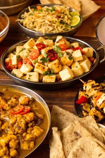 Assorted high-protein Indian dishes on a wooden table.