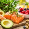 Assorted heart-healthy foods including salmon, avocado, berries, greens.
