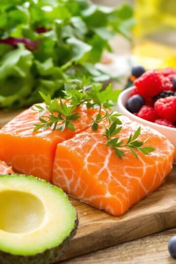 Assorted heart-healthy foods including salmon, avocado, berries, greens.