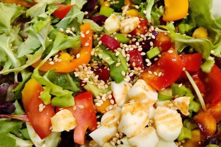 Colorful salad bowl with fresh vegetables and dressing.