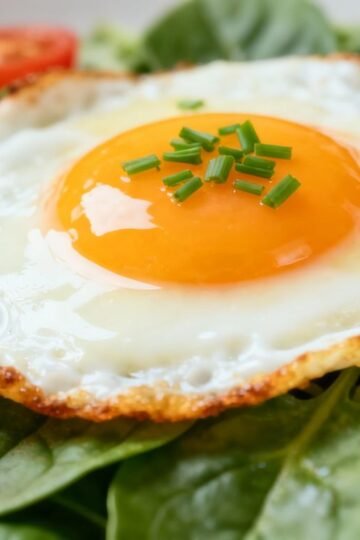 Healthy breakfast eggs with spinach and tomatoes.