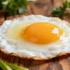 Healthy fried egg breakfast on a wooden table.