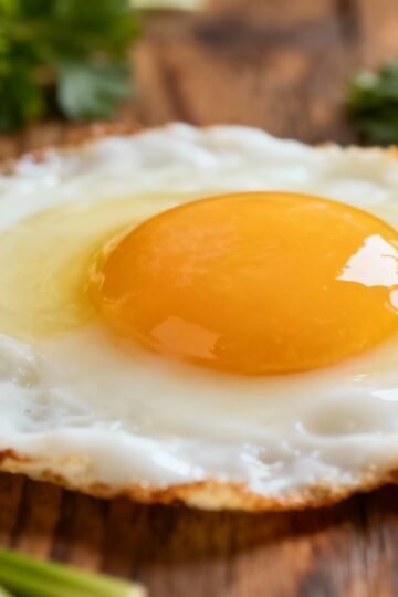 Healthy fried egg breakfast on a wooden table.
