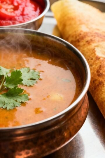 South Indian food spread with dosa, sambar, and chutney.