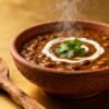 Steaming bowl of dal makhani with cream and cilantro.