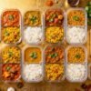 Indian food meal prep containers on a kitchen counter.