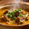Slow cooker lamb curry in a bowl with cilantro.