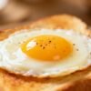 Fried egg on toast with runny yolk.