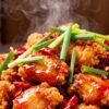 Spicy Chinese Chilli Chicken with fresh garnishes.