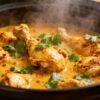 Crock pot chicken curry with spices and cilantro.