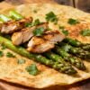 Chicken and asparagus wrap on a wooden board.