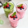 Healthy breakfast smoothies with fresh fruit garnishes.