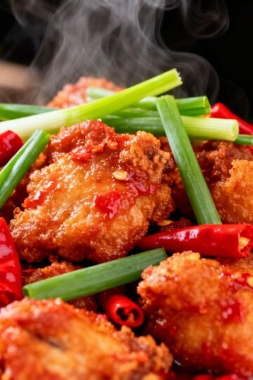 Authentic Chinese Chilli Chicken dish with garnishes.