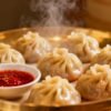 Steaming momos with chili sauce, a delicious dumpling dish.