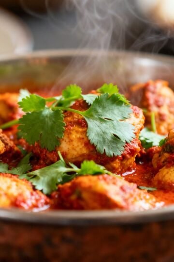 Authentic Indian chicken curry with spices and cilantro.